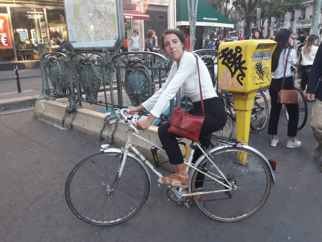 A vélo à Paris jeune femme à vélo devant une bouche de métro, à Paris