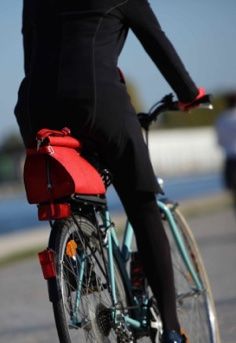 cycliste femme à vélo avec son sac sur le porte-bagages