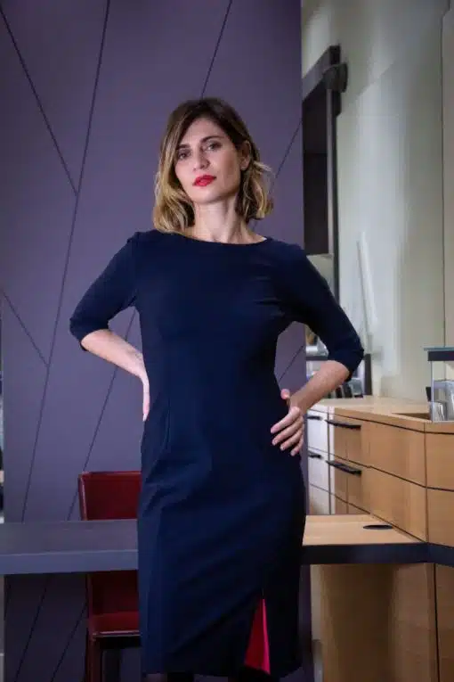 robe marine ou noire portée par une jeune femme debout dans un bureau ou une boutique, manches 3/4