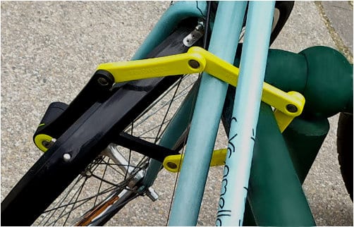 cadenas pliant fixant le cadre du vélo et la roue avant à un arceau à vélo